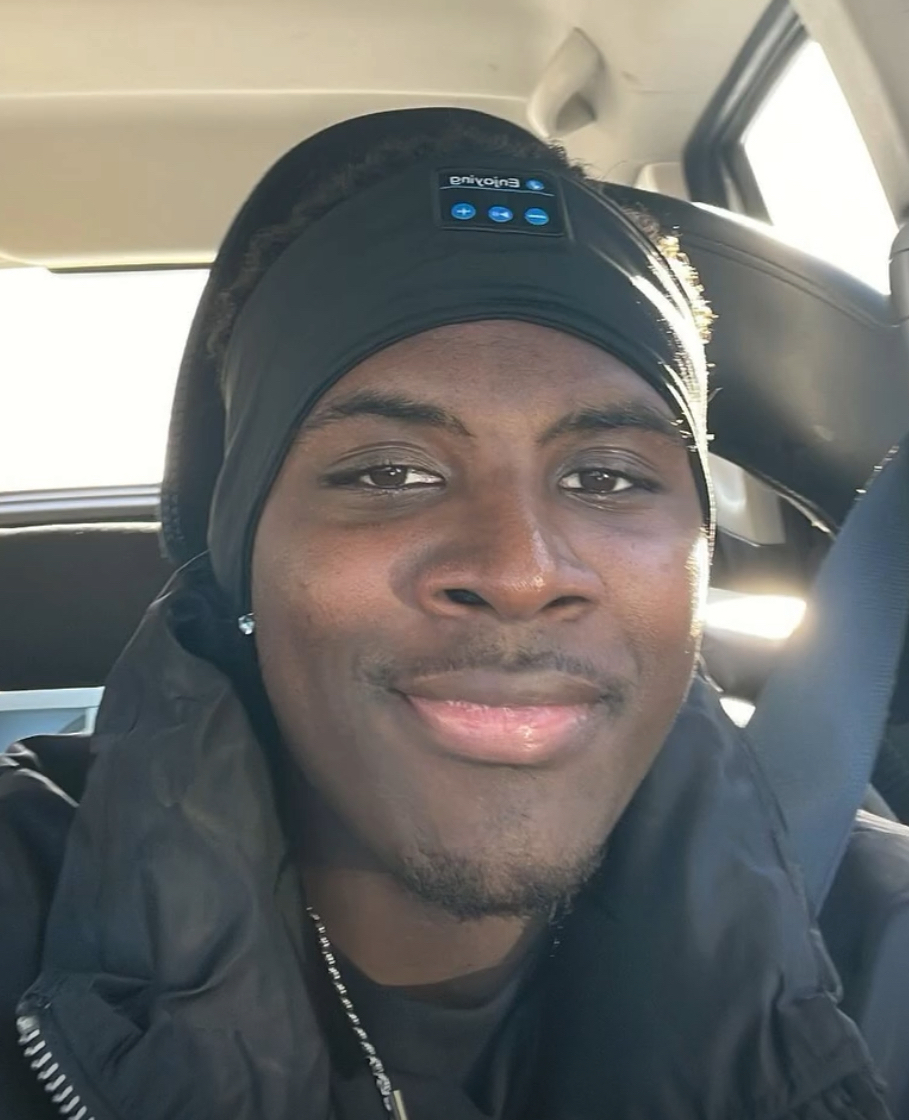 Person wearing a black headband in a car, smiling, representing a friendly and approachable image for a cleaning service blog.